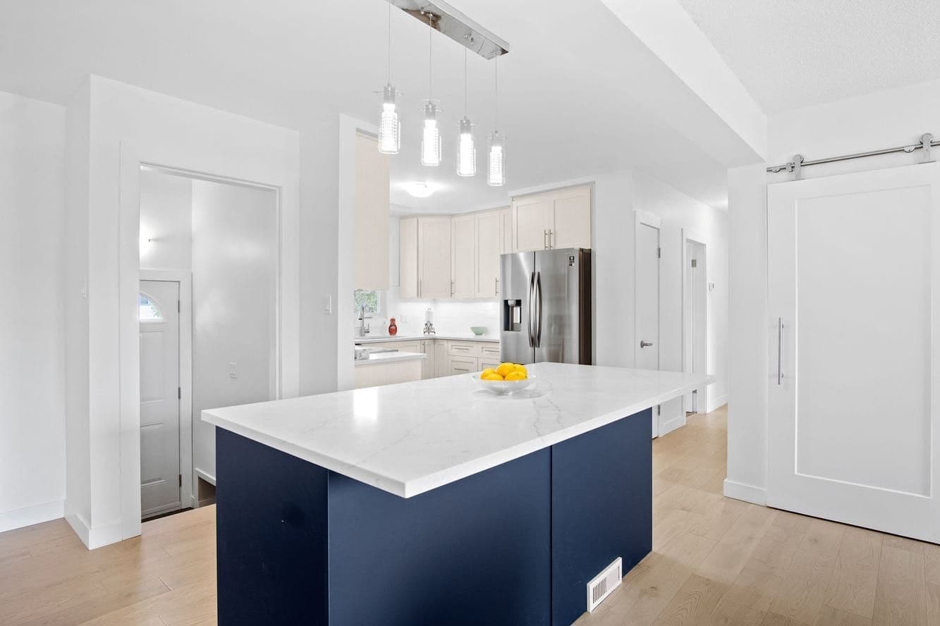 A navy island with a white countertop in an open kitchen — Malmo Plains